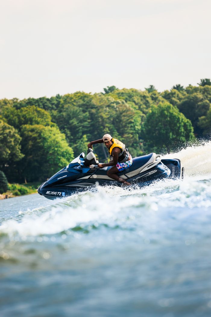 Man enjoying an exhilarating jet ski ride on the ocean with waves splashing around.